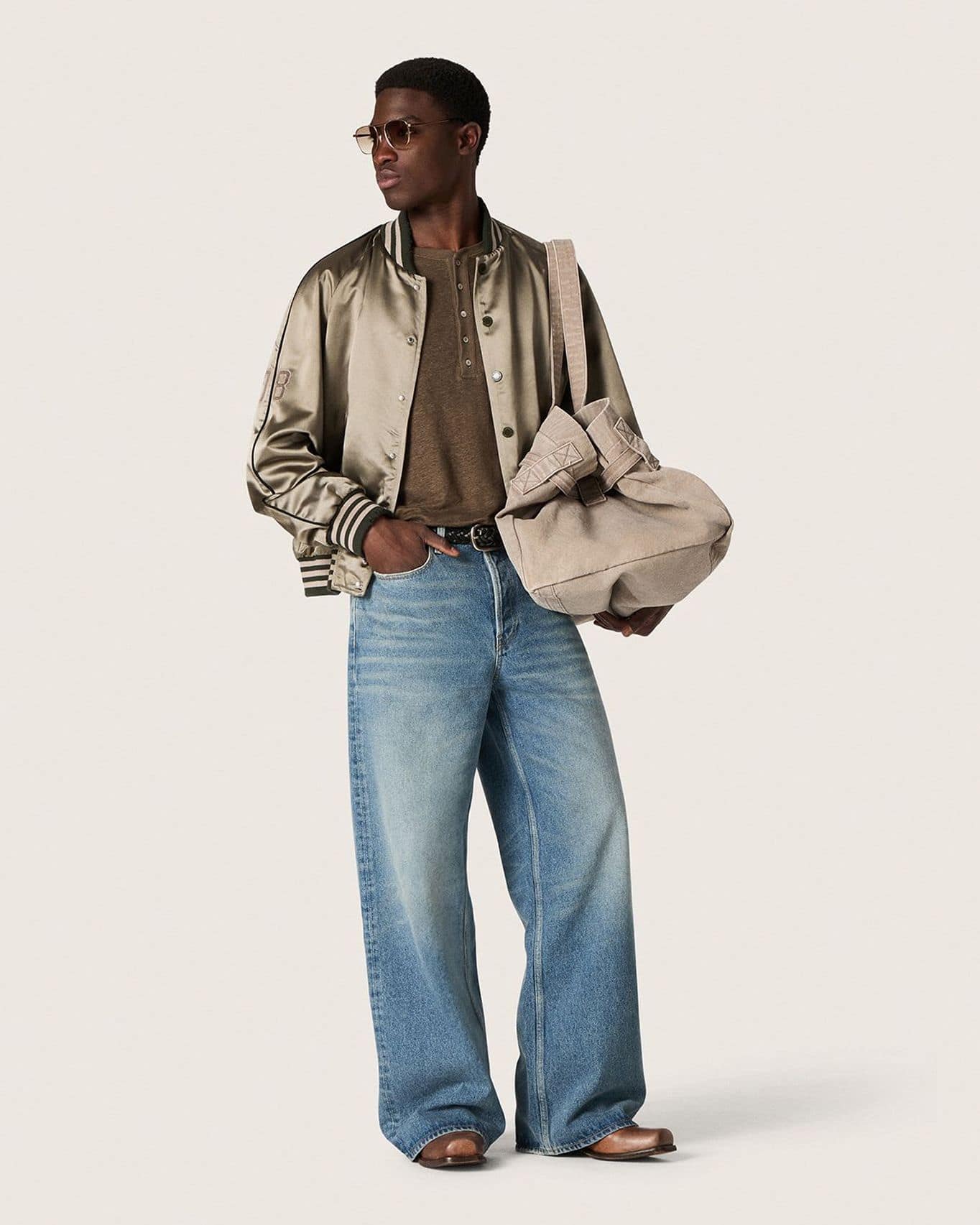 Male-model-with-sunglasses-wearing-beige-sweater-white-floreal-shirt-and-grey-pants